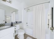 Thumbnail 10 of 45 - A white bathroom with a toilet, sink, and bathtub.