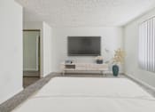 Thumbnail 9 of 45 - A bedroom with a bed, a tv, and a bench.