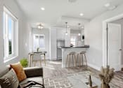 Thumbnail 3 of 10 - a living room with a kitchen with a bar and a couch