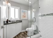 Thumbnail 8 of 10 - a white bathroom with a shower toilet and sink