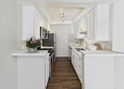 Thumbnail 1 of 41 - A kitchen with white cabinets and a black fridge.