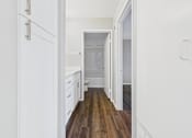 Thumbnail 6 of 41 - A white kitchen with wooden floors and white cabinets.