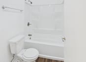 Thumbnail 8 of 41 - A white toilet sits next to a white bathtub in a bathroom.