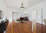 Thumbnail 19 of 61 - A living room with a brown chair and a wooden floor.