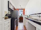 Thumbnail 8 of 61 - A kitchen with a black fridge and white cabinets.