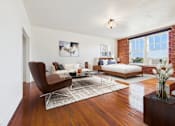 Thumbnail 11 of 61 - A living room with a brown chair and a white couch.
