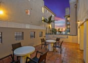 Thumbnail 22 of 66 - a patio with tables and chairs and a sunset in the background