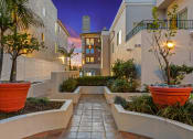 Thumbnail 15 of 66 - a walkway between two apartment buildings with potted plants