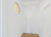 Thumbnail 8 of 20 - A white room with a round mirror on the wall.
