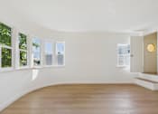 Thumbnail 5 of 20 - A room with a wooden floor and white walls.