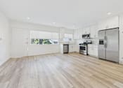 Thumbnail 3 of 30 - A kitchen with white cabinets and stainless steel appliances.