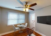 Thumbnail 17 of 21 - A dining room with a table and chairs and a ceiling fan.