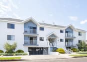 Thumbnail 6 of 32 - a white apartment building with a street in front of it