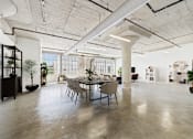 Thumbnail 6 of 123 - A large, open-plan office space with a dining table in the center.