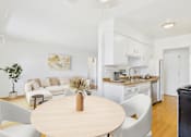 Thumbnail 4 of 19 - A modern kitchen with a dining table and chairs.
