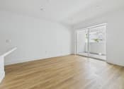 Thumbnail 59 of 136 - A room with wooden flooring and a sliding glass door.