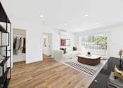 Thumbnail 12 of 32 - A modern living room with a white sofa and a wooden coffee table.
