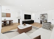 Thumbnail 13 of 32 - A modern living room with a white couch and a coffee table.