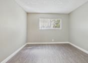 Thumbnail 43 of 51 - A room with a window and wooden flooring.