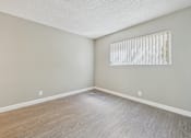 Thumbnail 40 of 51 - A room with a window and wooden flooring.