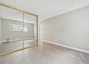 Thumbnail 41 of 51 - A room with a wooden floor and a large mirror on the wall.