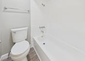 Thumbnail 50 of 51 - A white toilet sits next to a white bathtub in a bathroom.