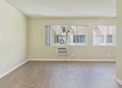 Thumbnail 32 of 51 - A room with a wooden floor and a large window.