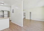 Thumbnail 24 of 51 - A kitchen with white cabinets and a wooden floor.