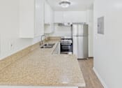 Thumbnail 21 of 51 - A kitchen with a granite counter top and stainless steel appliances.