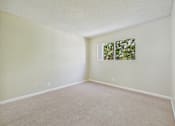 Thumbnail 27 of 51 - A room with a window and a carpeted floor.