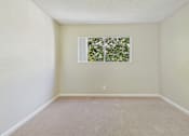 Thumbnail 31 of 51 - A room with a window and carpeted floor.
