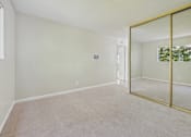 Thumbnail 28 of 51 - A room with a carpet floor and a large mirror on the wall.