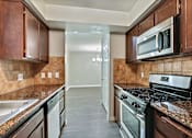 Thumbnail 1 of 33 - A kitchen with a black stove top oven and a black microwave.