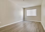 Thumbnail 8 of 33 - A room with wooden flooring and a window with blinds.