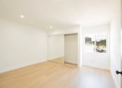 Thumbnail 16 of 28 - a living room with a wood floor and white walls