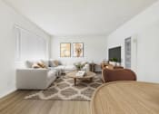 Thumbnail 2 of 65 - A living room with a grey couch, a brown chair, and a wooden table.