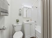 Thumbnail 12 of 65 - A white toilet sits next to a white sink in a bathroom.