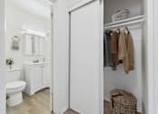 Thumbnail 10 of 65 - A white bathroom with a toilet, sink, and a wicker basket.