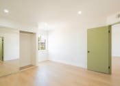 Thumbnail 17 of 28 - a living room with white walls and a green door