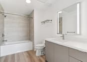 Thumbnail 137 of 163 - A white bathroom with a tub, toilet, and sink.
