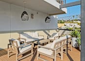 Thumbnail 22 of 119 - A patio with wooden furniture and hanging lamps.