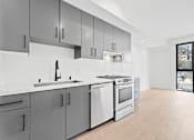 Thumbnail 43 of 119 - A modern kitchen with a white countertop and stainless steel appliances.