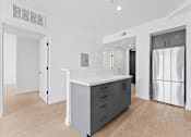 Thumbnail 45 of 119 - A modern kitchen with a white island and stainless steel appliances.