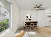 Thumbnail 4 of 30 - A dining room with a table and chairs and a ceiling fan.