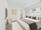 Thumbnail 6 of 30 - A bedroom with a large bed and a nightstand with a lamp on it.