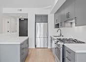 Thumbnail 48 of 119 - A modern kitchen with a refrigerator, stove, and cabinets.