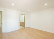 Thumbnail 21 of 28 - a living room with white walls and a wooden floor