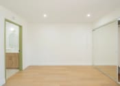 Thumbnail 22 of 28 - a living room with white walls and a sliding glass door to a bathroom