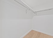 Thumbnail 57 of 119 - A white wall with a wooden floor and a white ceiling with a metal pipe.