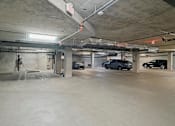 Thumbnail 27 of 119 - A parking garage with a few cars and a hose.